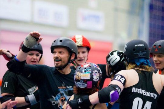 A roller derby team does a group hug after a game