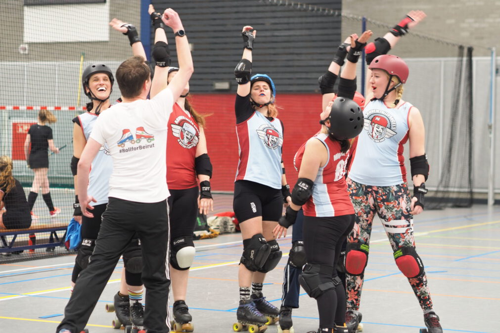 A roller derby team is cheering